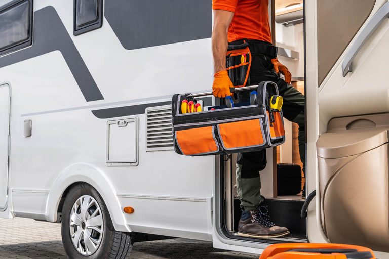 rv technician entering a motorhome with toolbox
